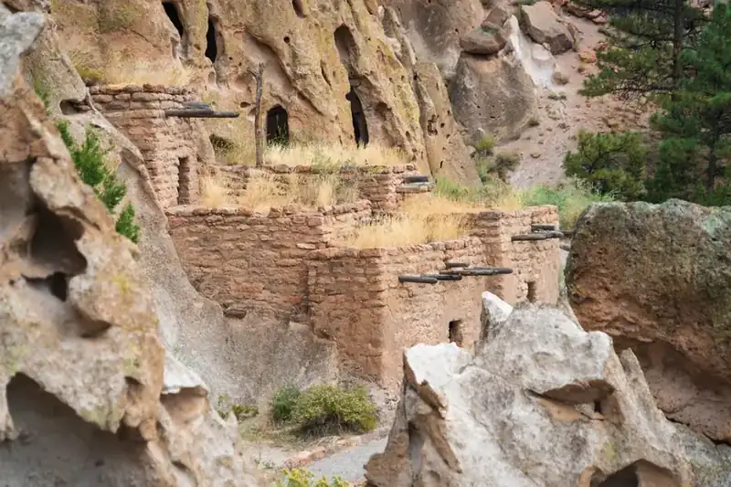 Masonry rooms built against the cliff below carved cavates