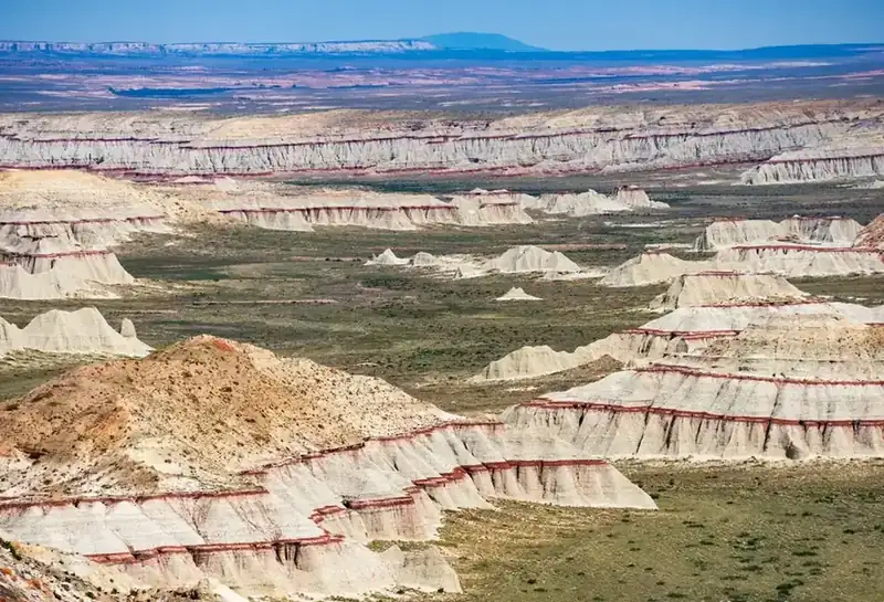 Layered badlands striped with red running to the horizon near Coal Mine Canyon