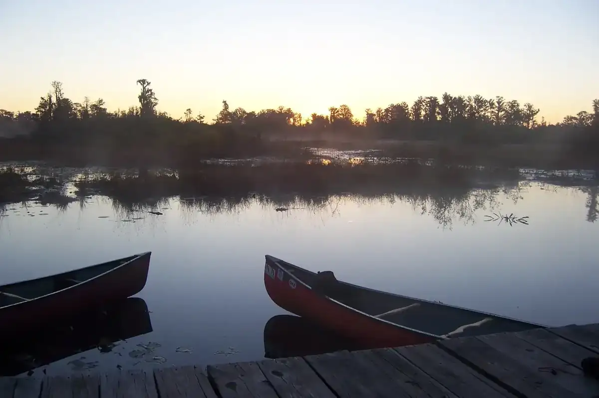 Canoes on the water at dawn in the Okefenokee Swamp