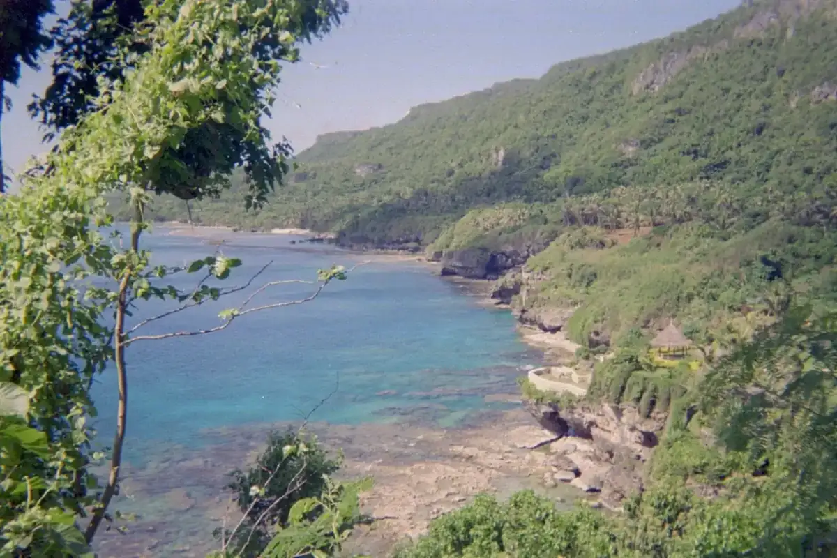 The coast of Rota, with cliffs standing above a turquoise reef